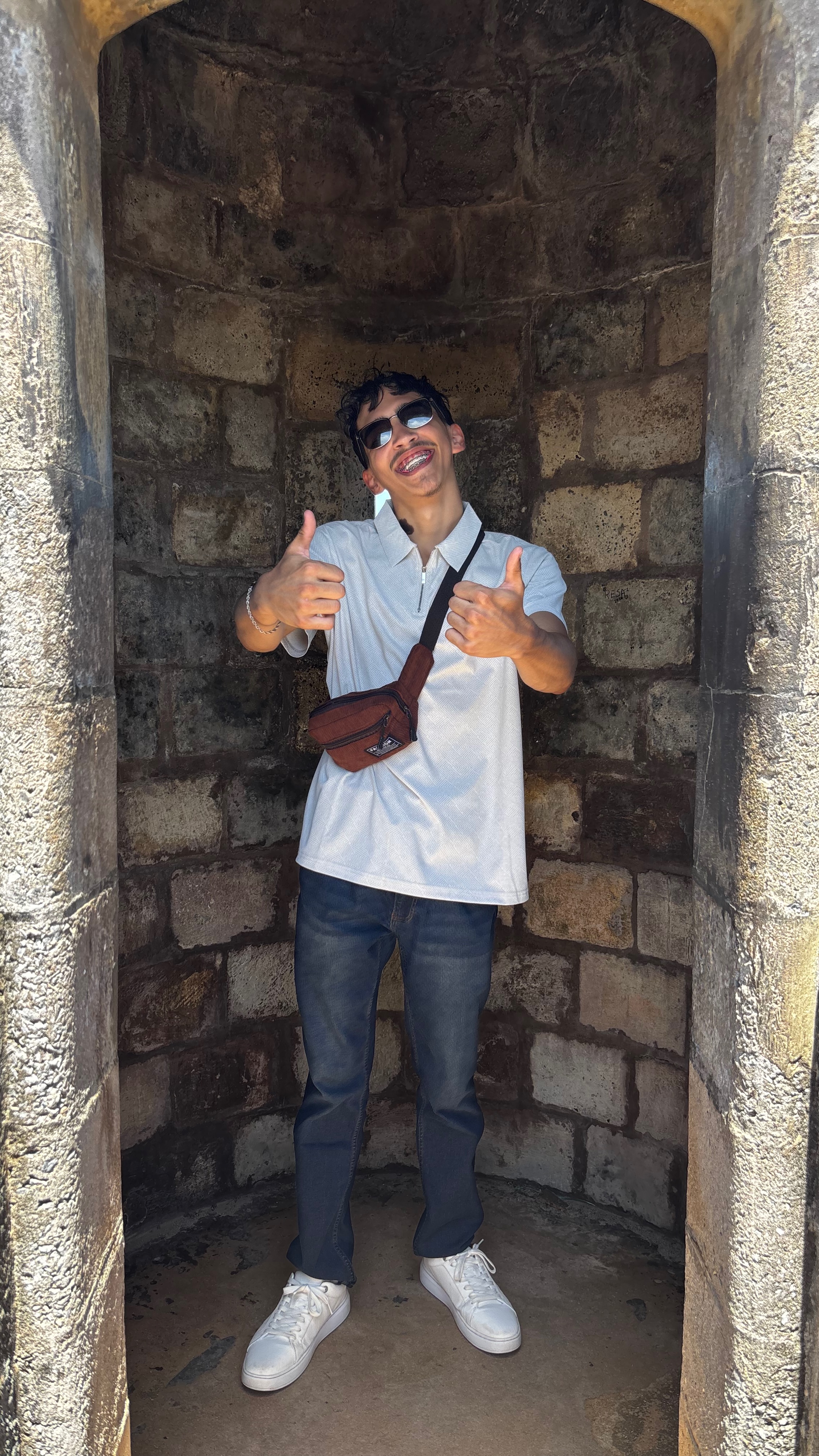 Josiah smiling in a historic stone archway in Puerto Rico